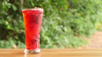 Colorful soft drinks poured into glasses and placed on the table. There is a natural background. video