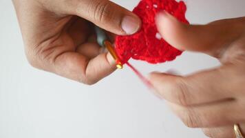 Hand close up crocheting with a hook, wool yarn, creative craft video