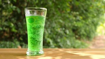 Colorful soft drinks poured into glasses and placed on the table. There is a natural background. video