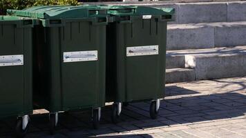 Metal green garbage can with wheels in countryside video