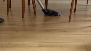 a woman use a vacuum to clean the floor in her home. video