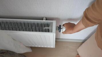 woman holding temperature knob of heating radiator video