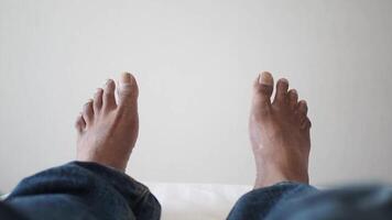 Relaxed bare feet on a plain white background in a closeup perspective for a soothing experience video