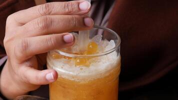 mano de mujer sosteniendo un vaso de jugo de naranja video