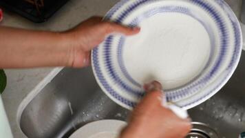 Hand with sponge cleaning dirty plate video