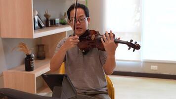 asiatico uomo giocando violino nel camera video