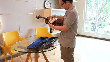 asiático hombre jugando violín en habitación video