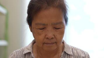 vecchio asiatico donna prende cura di impianti nel il giardino di sua casa. video