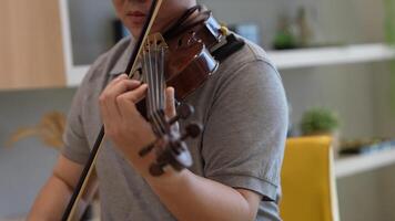 Asian man playing violin in room video