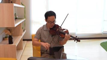 asiático hombre jugando violín en habitación video