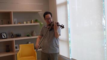 asiático hombre jugando violín en habitación video