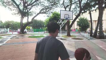de manlig och kvinna basketboll spelare öva använder sig av de boll i de parkera domstol flitigt och lyckligt. video