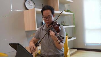 asiático hombre jugando violín en habitación video