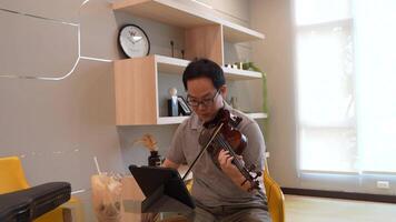 asiático hombre jugando violín en habitación video