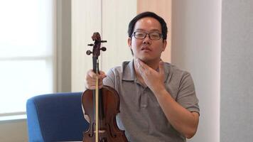 asiático hombre jugando violín en habitación video