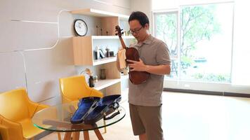 Asian man playing violin in room video