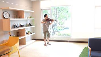 asiático hombre jugando violín en habitación video