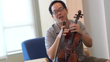 asiatique homme en jouant violon dans pièce video