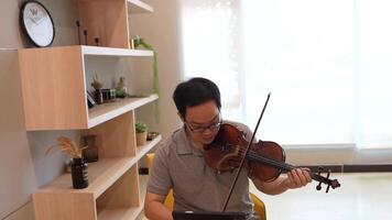 asiatico uomo giocando violino nel camera video