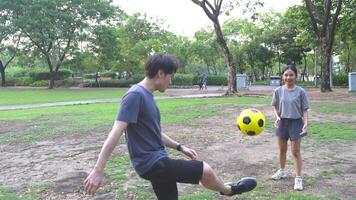 Masculin et femelle football joueurs entraine toi en utilisant le Balle dans le parc champ avec diligence et Heureusement. video