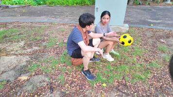 manlig och kvinna fotboll spelare öva använder sig av de boll i de parkera fält flitigt och lyckligt. video