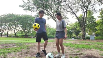 maschio e femmina calcio Giocatori pratica utilizzando il palla nel il parco campo diligentemente e felicemente. video