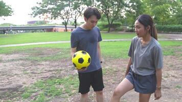 männlich und weiblich Fußball Spieler trainieren mit das Ball im das Park Feld fleißig und glücklich. video