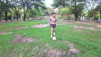 Woman playing football in park field video