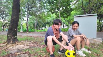 männlich und weiblich Fußball Spieler trainieren mit das Ball im das Park Feld fleißig und glücklich. video