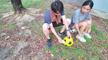 manlig och kvinna fotboll spelare öva använder sig av de boll i de parkera fält flitigt och lyckligt. video