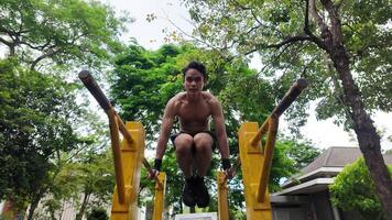 Asian man practicing gymnastics doing gymnastics bar and hoop exercises and stretching and resting for sports. video