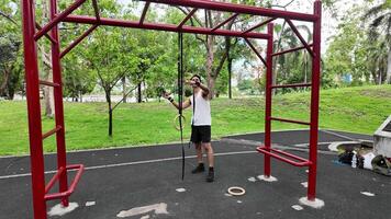 Asian man practicing gymnastics doing gymnastics bar and hoop exercises and stretching and resting for sports. video