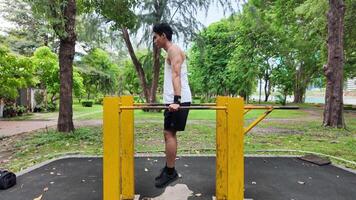 Asian man practicing gymnastics doing gymnastics bar and hoop exercises and stretching and resting for sports. video