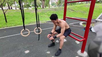 asiático hombre practicando gimnasia haciendo gimnasia bar y aro ejercicios y extensión y descansando para Deportes. video