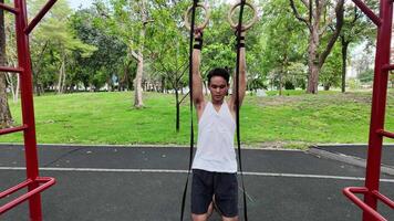 asiático hombre practicando gimnasia haciendo gimnasia bar y aro ejercicios y extensión y descansando para Deportes. video