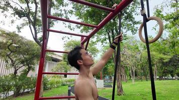 Asian man practicing gymnastics doing gymnastics bar and hoop exercises and stretching and resting for sports. video