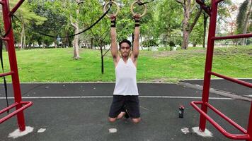 asiático hombre practicando gimnasia haciendo gimnasia bar y aro ejercicios y extensión y descansando para Deportes. video