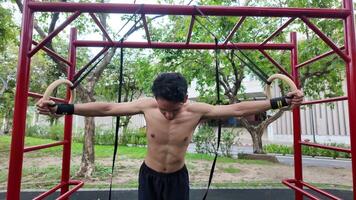 asiático hombre practicando gimnasia haciendo gimnasia bar y aro ejercicios y extensión y descansando para Deportes. video