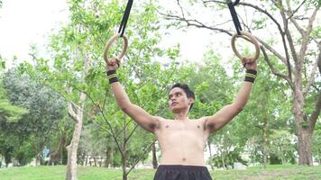 Asian man practicing gymnastics doing gymnastics bar and hoop exercises and stretching and resting for sports. video