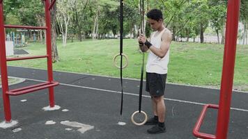 Asian man practicing gymnastics, doing gymnastics bar and hoop exercises and stretching, resting for sports. video