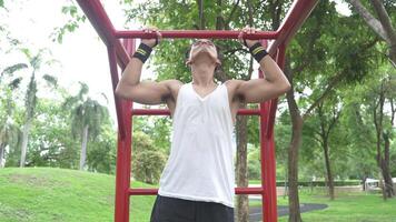 Asian man practicing gymnastics doing gymnastics bar and hoop exercises and stretching and resting for sports. video