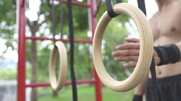 Asian man practicing gymnastics doing gymnastics bar and hoop exercises and stretching and resting for sports. video