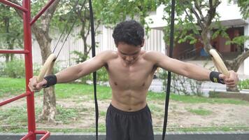 Asian man practicing gymnastics doing gymnastics bar and hoop exercises and stretching and resting for sports. video