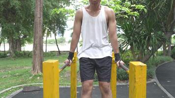 Asian man practicing gymnastics doing gymnastics bar and hoop exercises and stretching and resting for sports. video