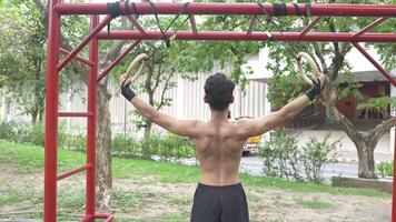 Asian man practicing gymnastics doing gymnastics bar and hoop exercises and stretching and resting for sports. video