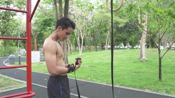 Asian man practicing gymnastics doing gymnastics bar and hoop exercises and stretching and resting for sports. video