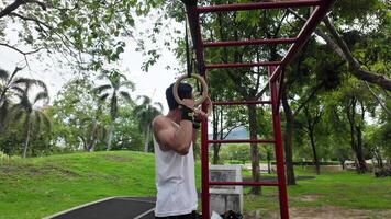 Asian man practicing gymnastics doing gymnastics bar and hoop exercises and stretching and resting for sports. video