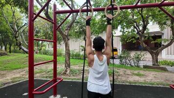 asiático hombre practicando gimnasia haciendo gimnasia bar y aro ejercicios y extensión y descansando para Deportes. video