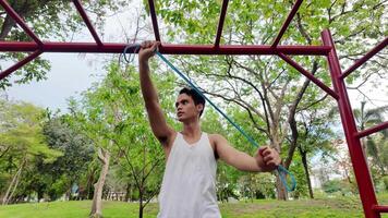 Asian man practicing gymnastics doing gymnastics bar and hoop exercises and stretching and resting for sports. video