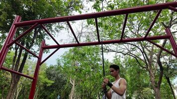 Asian man practicing gymnastics doing gymnastics bar and hoop exercises and stretching and resting for sports. video